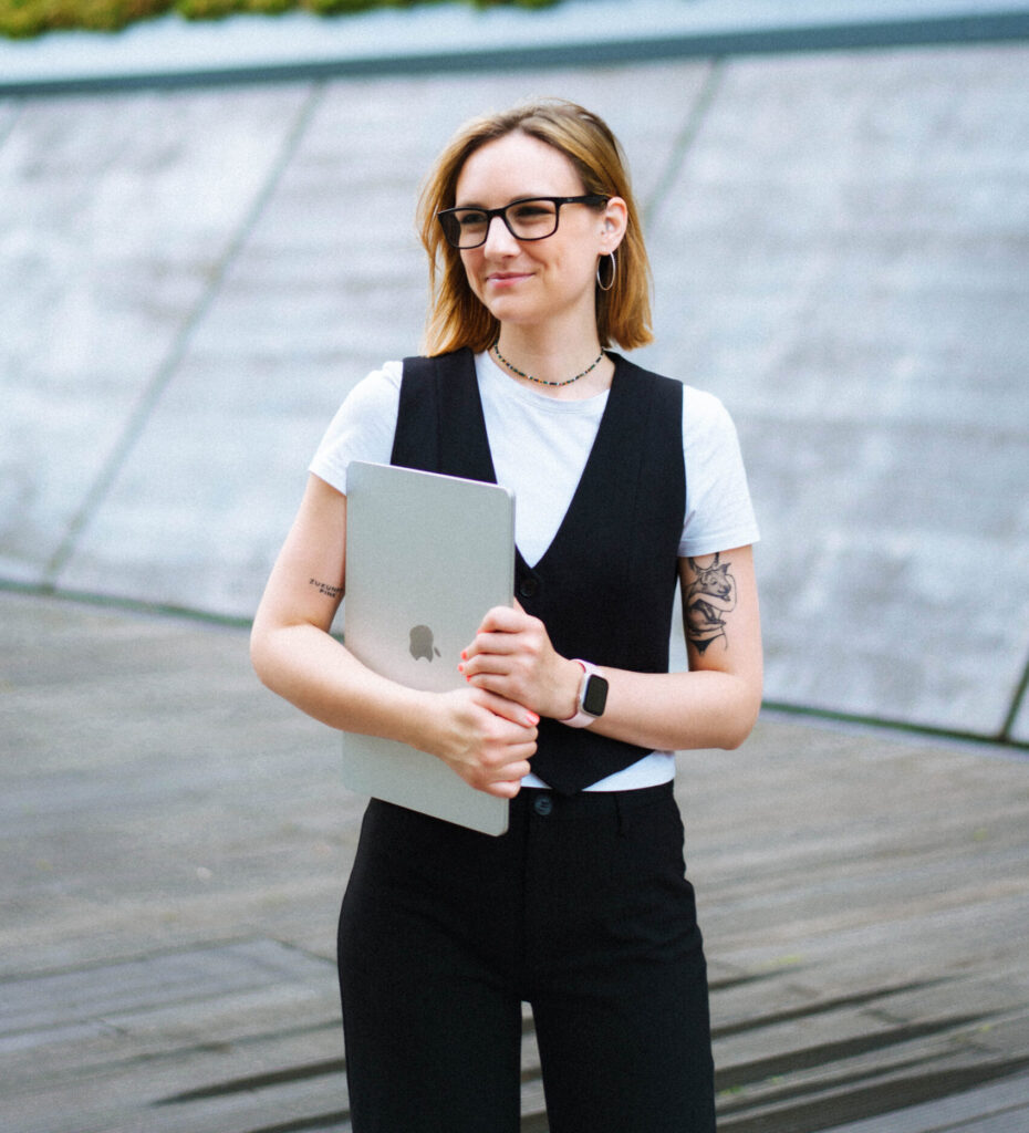 Dame hält Laptop in der Hand und sieht in die Ferne