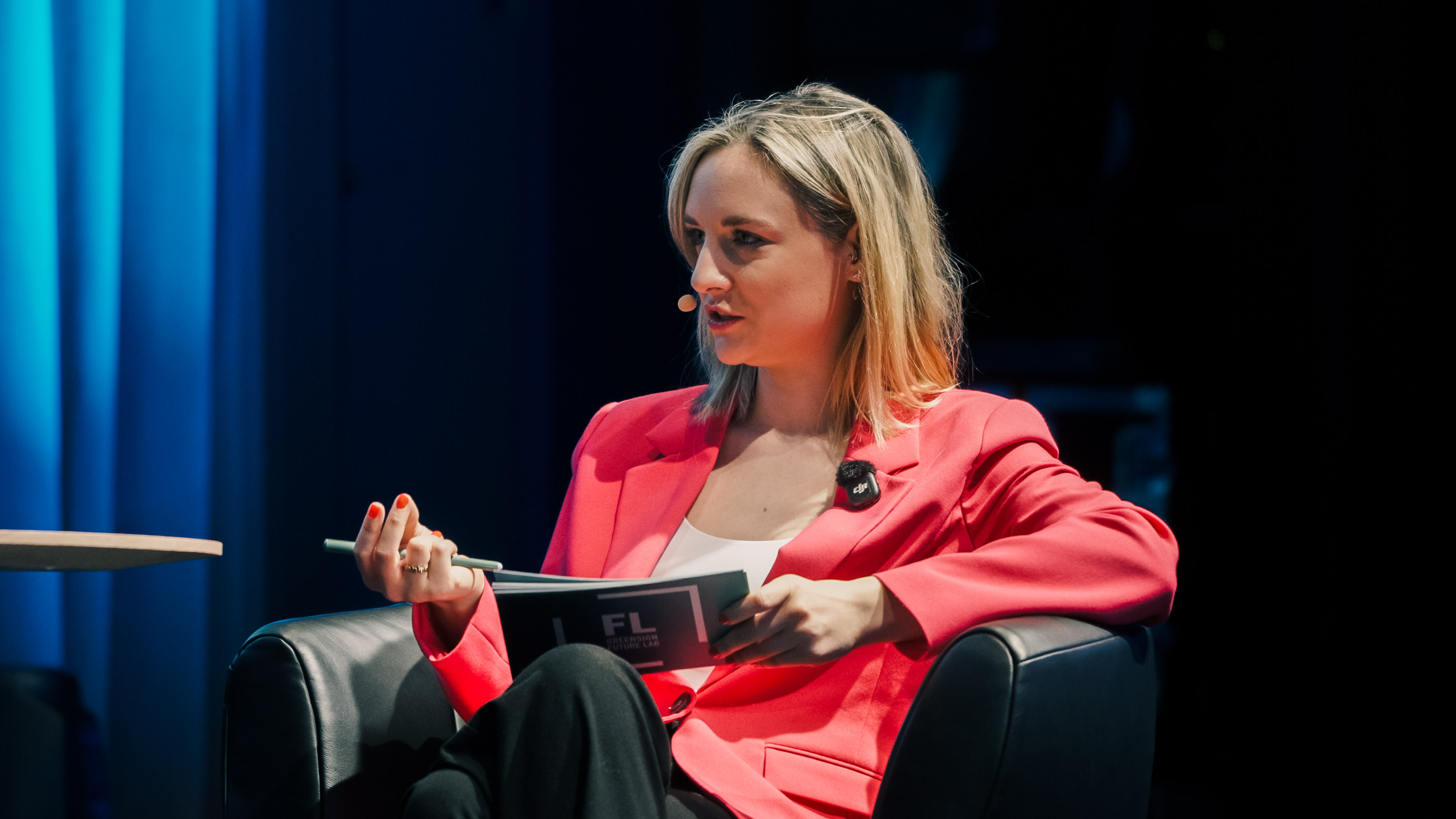Dame im roten Blazer moderiert gestikulierend